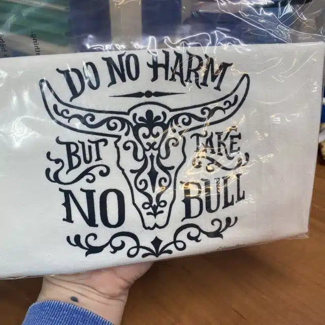cotton tea towel that says do no harm but take no bull with a decorative cow skull